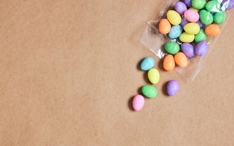 A open packet of small colourful chocolate easter eggs.